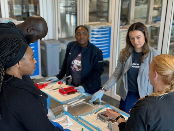 a group of students in a lab receiving instruction on how to use anesthesiology equipment