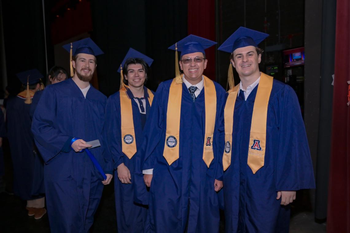 A group of four graduates pose for a phto